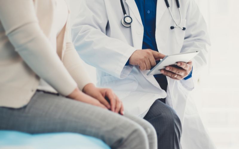 medico con bata blanca explica a paciente